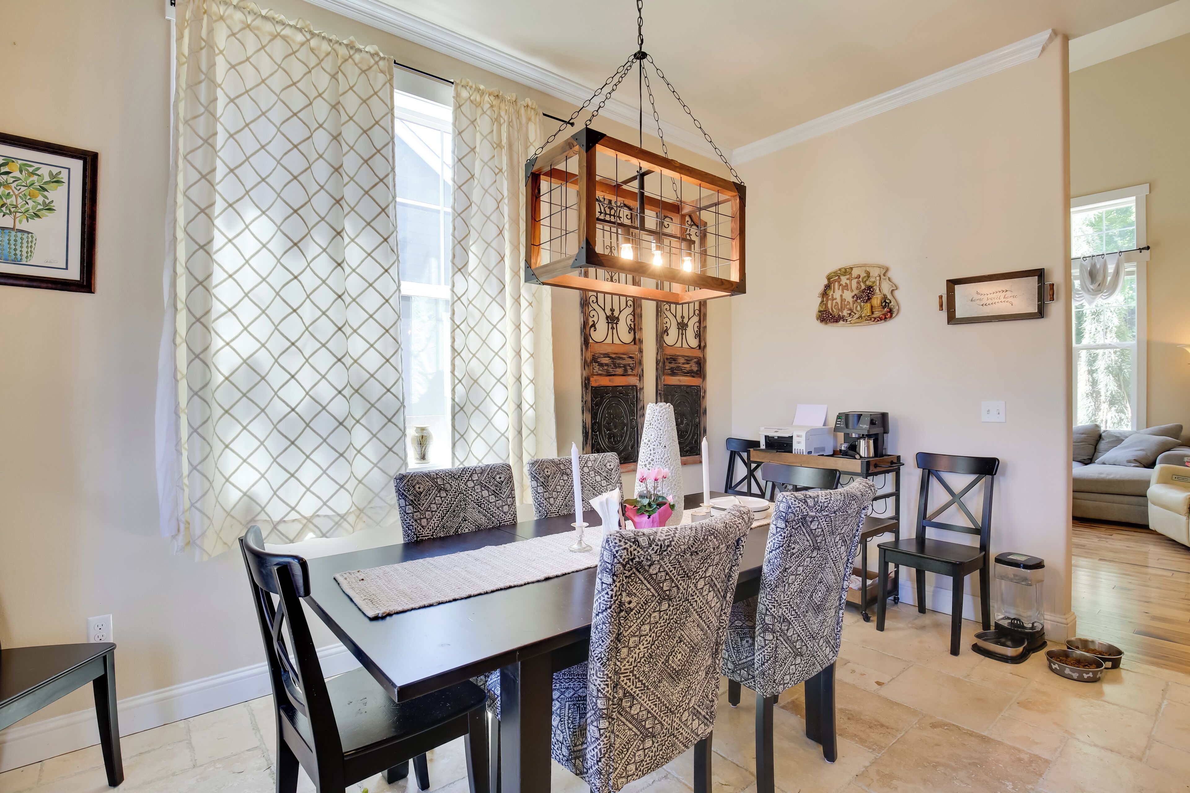 A dining area with a table, chairs, and a hanging light fixture.