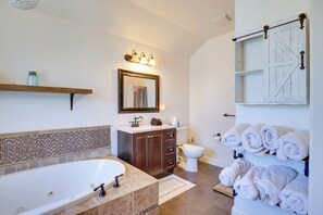 A bathroom with a bathtub, a toilet, a sink, and a mirror. - Backyard Resort,hottub,heated Pool,firepit,uofo 6m (Eugene)