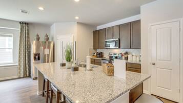 A modern kitchen with granite countertops, stainless steel appliances, and wooden cabinets.