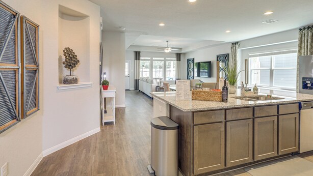 A modern kitchen with a central island, built-in appliances, and a view to the dining area. - Walk to Brazos County Expo: Elegant Home w/ Grill! (Bryan)