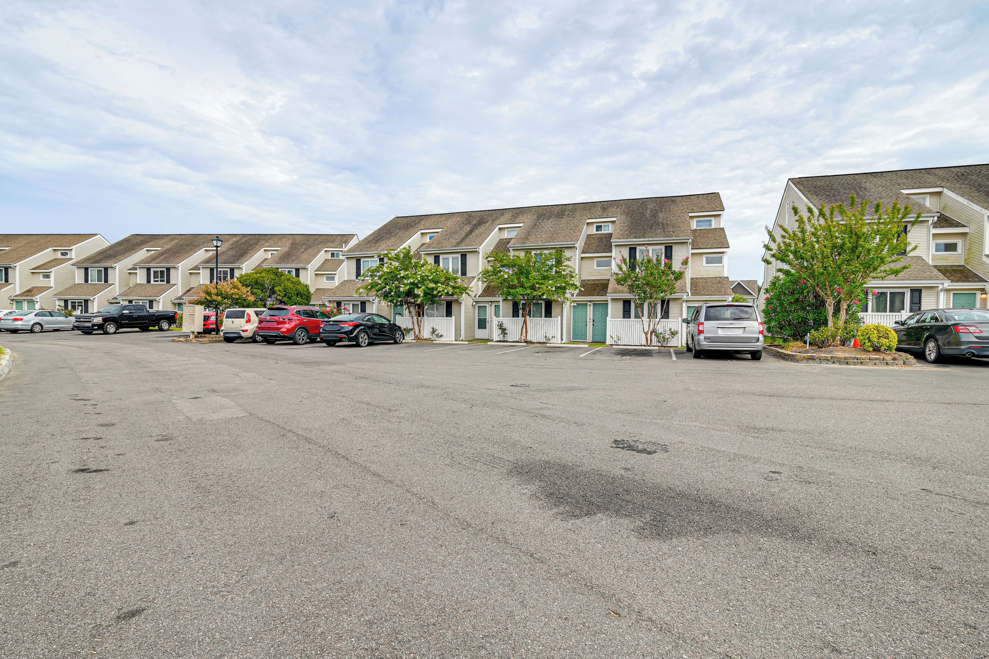 Une rangée de maisons de ville avec un parking devant.