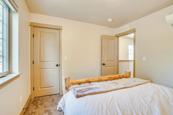 Une chambre à coucher avec un lit, une fenêtre et deux portes.