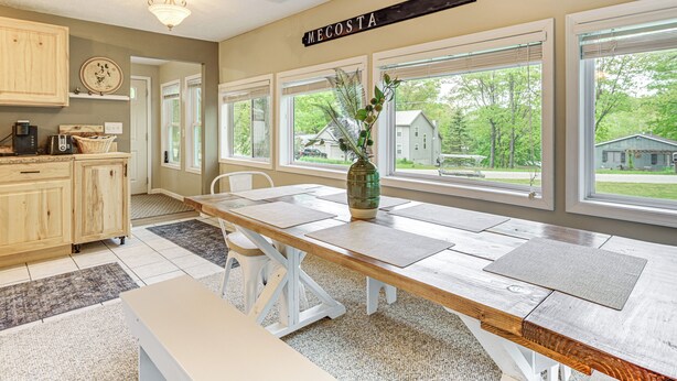 A kitchen with a wooden table, a bench, and a sign that reads "MECOSTA". - 2 MI to the Lake: Mecosta Getaway With Fire Pit! (Mecosta)