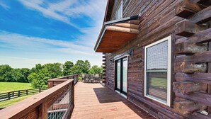 A wooden deck with a railing, a table and chairs, and a glass door leading to an outdoor area. - Scenic Getaway w/ Deck: 7 Mi to Mammoth Cave Park! (Brownsville)