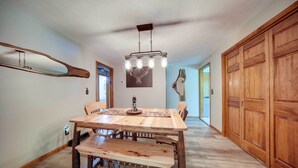 A dining area with a wooden table and benches, a hanging light fixture, and wooden paneling on the walls. - Pet-friendly Espyville Home w/ Yard & Fire Pit! (Linesville)
