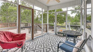 A covered patio with a ceiling fan, a patterned rug, and a table with chairs. - Family-friendly Harrells Home w/ Fire Pit + Kayaks (Harrells)