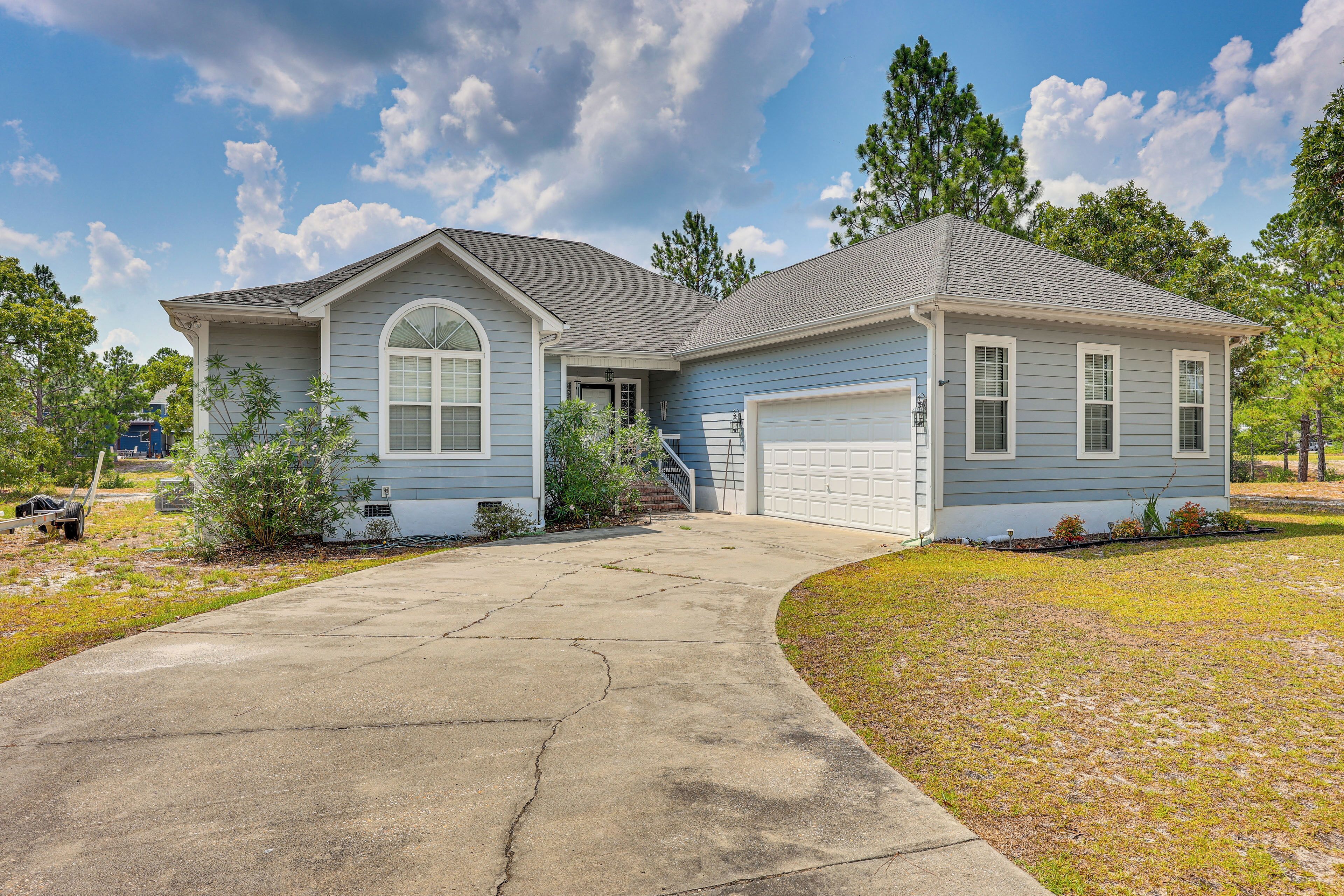 A two-story house with a garage, a driveway, and a lawn.