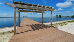 A wooden pier leading to a beach with a pergola structure. - Family-friendly Harrells Home w/ Fire Pit + Kayaks (Harrells)