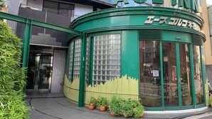 A green building with the sign "ACE INN" and Japanese text. - Ace Inn Shinjuku - Hostel (Tokyo)
