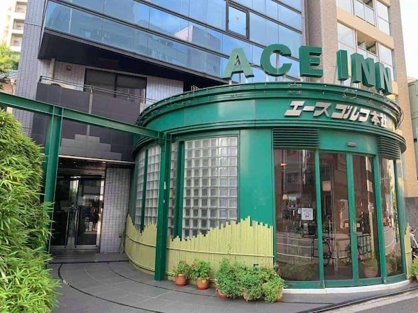 A green building with the sign "ACE INN" and Japanese text.