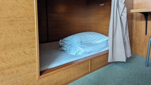 A single bed with a wooden headboard and a curtain. - Ace Inn Shinjuku - Hostel (Tokyo)