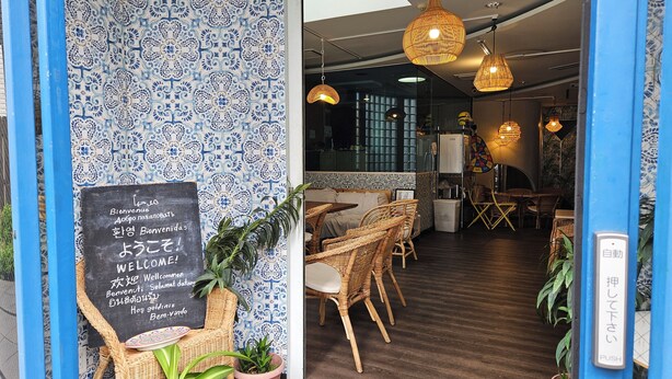 A restaurant interior with blue patterned walls, wicker furniture, and hanging wicker lamps. - Ace Inn Shinjuku - Hostel (Tokyo)