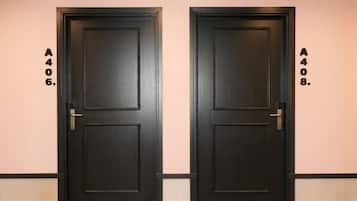 Dos puertas de color oscuro idénticas, con un número en la pared junto a cada una.