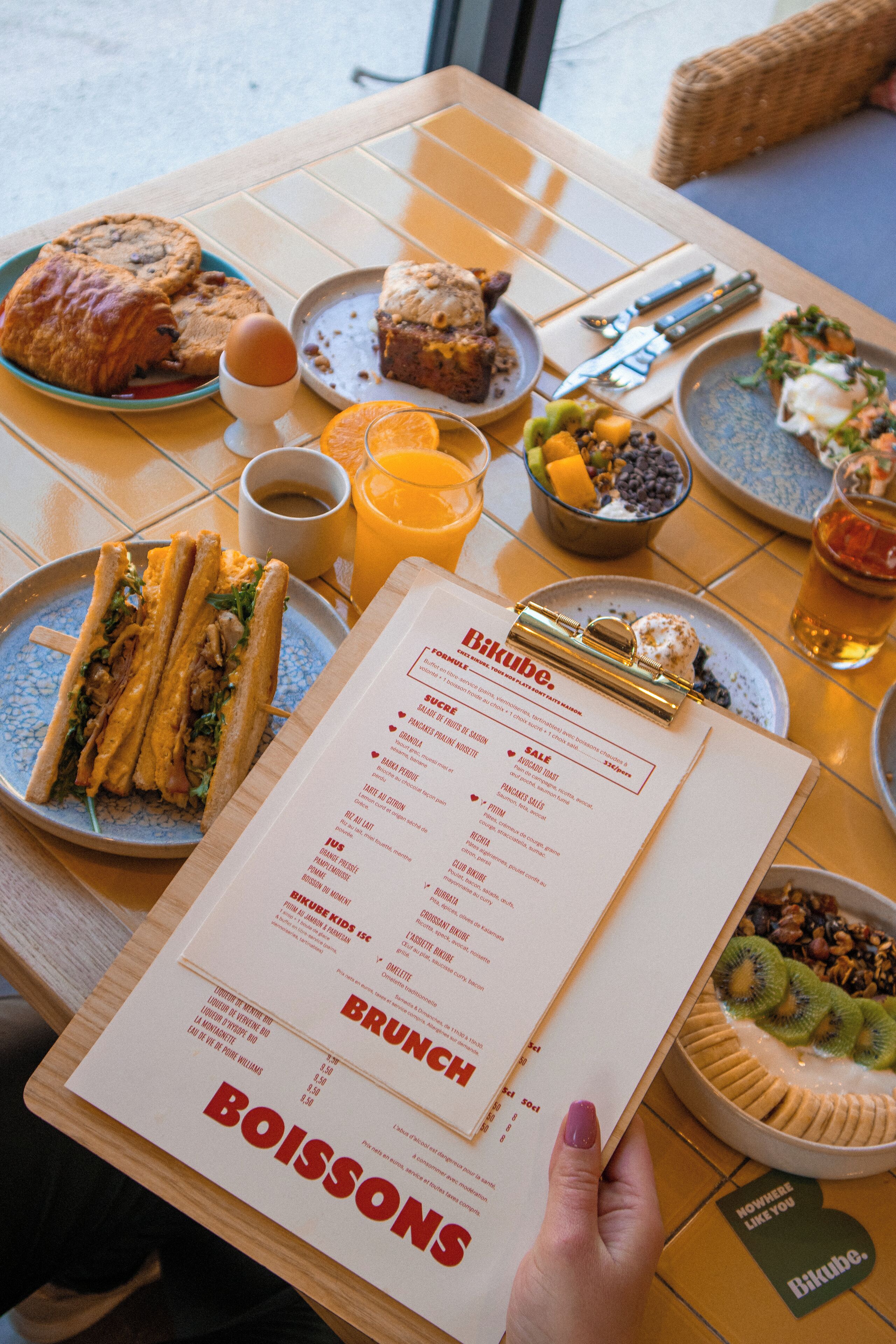 A menu with brunch options and a table set with various dishes.