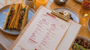 A menu with brunch options and a table set with various dishes.