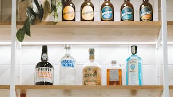 Une étagère à bouteilles contenant diverses sortes de spiritueux, notamment de la vodka Absolut et du Kahlua.