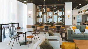 Een modern interieur met een eethoek, banken en een boekenkast.