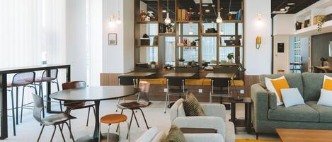Un interior moderno con comedor, sofás y estantería.