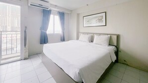 Habitación de hotel con una cama grande, una ventana con cortinas, un equipo de aire acondicionado y un cuadro en la pared.