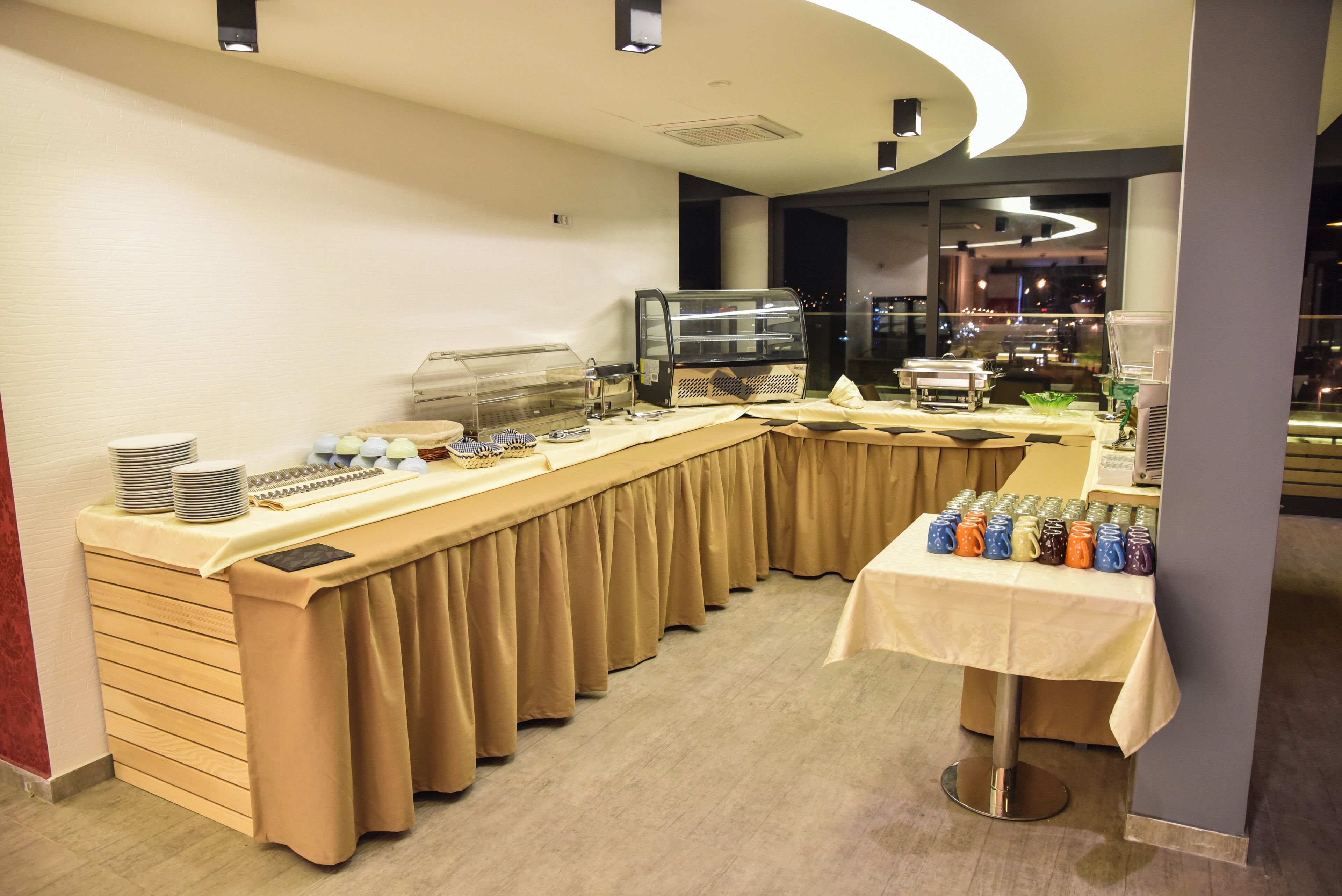 A buffet setup with a long counter, a coffee machine, and a variety of food items.