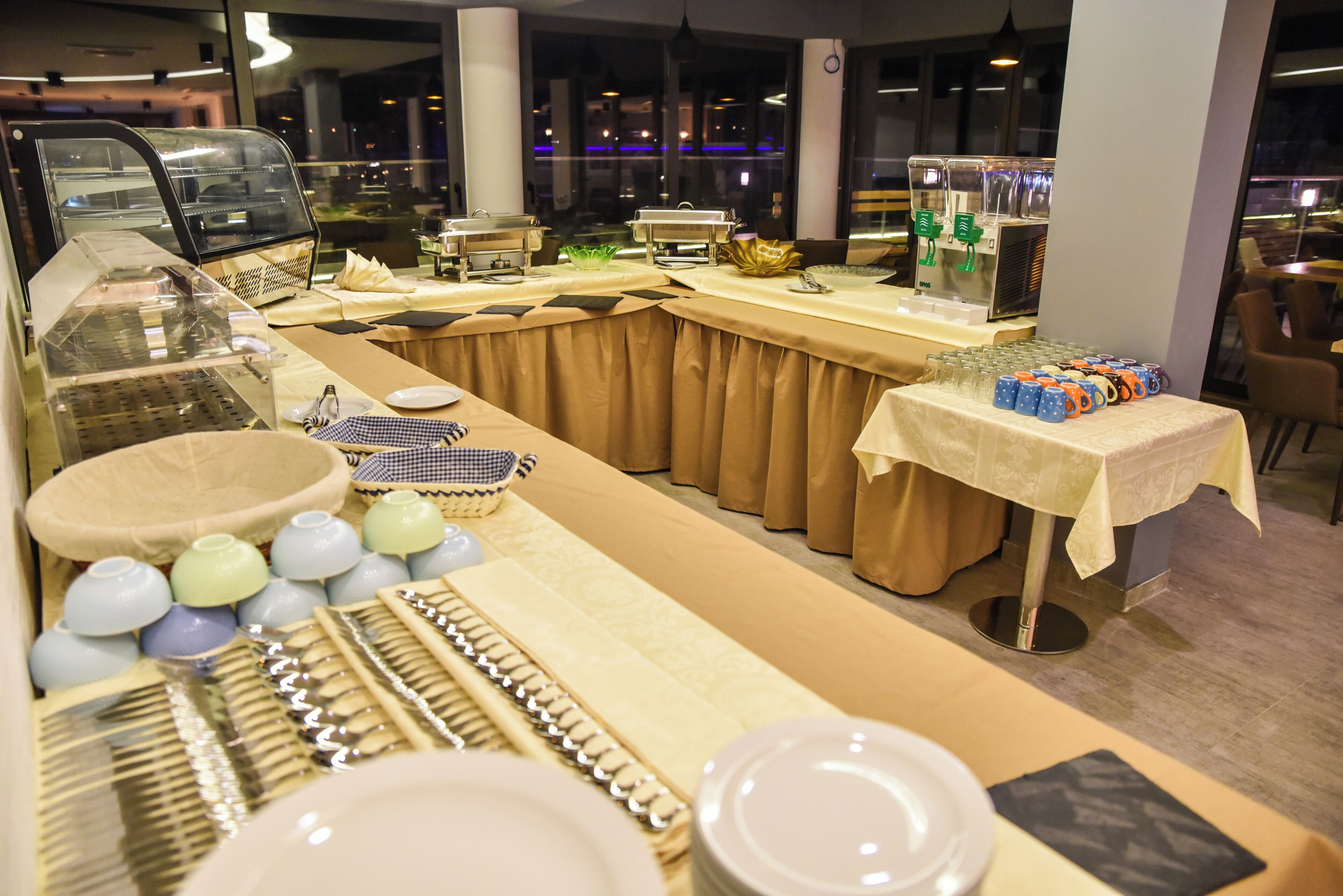 Disposição de buffet com diversos alimentos e utensílios.