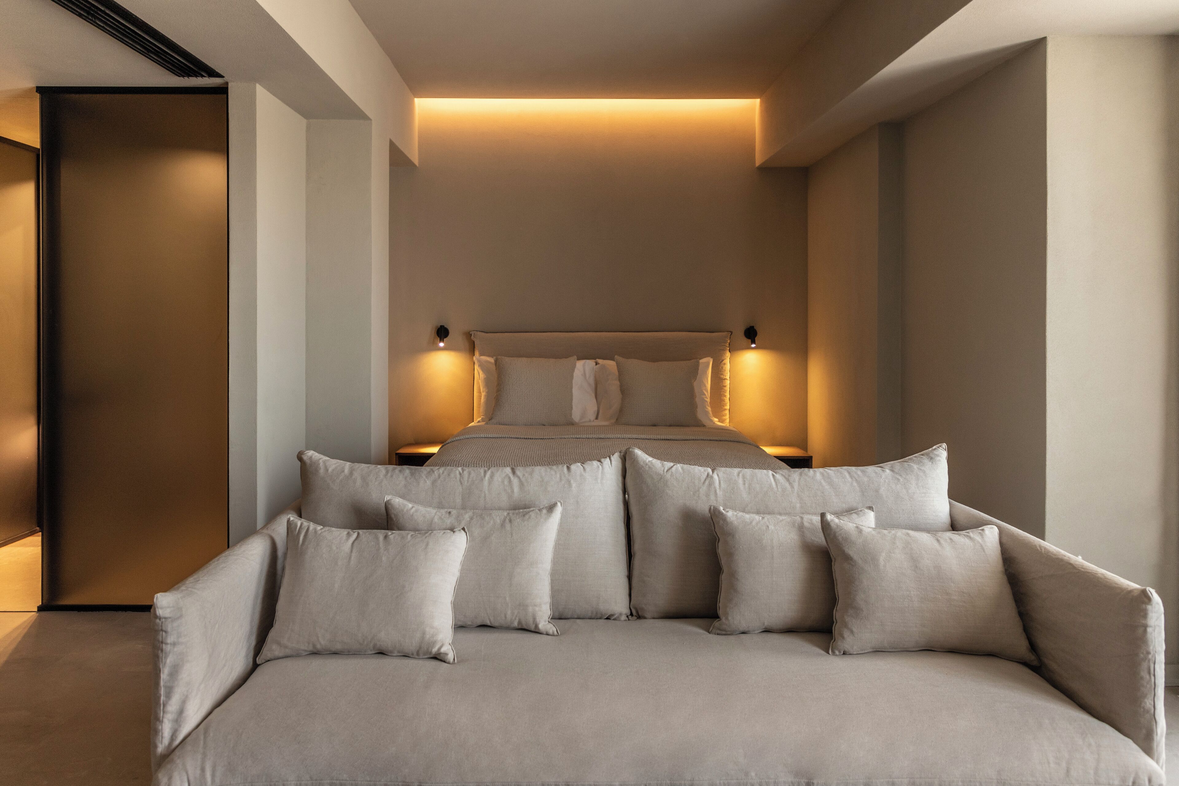 Ein modernes Schlafzimmer mit einem großen Bett, einer Schlafcouch und zwei Nachttischen.
