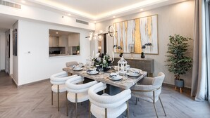 A modern dining area with a marble table, white chairs, and a decorative centerpiece. - Lamtara 1 - Mint Stay (Dubai)