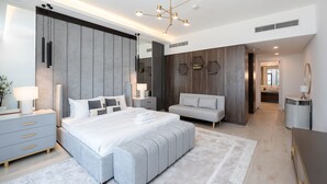 A modern bedroom with a large bed, bedside tables, a sofa, and a walk-in closet. - Lamtara 1 - Mint Stay (Dubai)