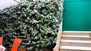 A wooden staircase leading to a green door, surrounded by a dense hedge. - Beachfront Villa with WiFi, Terrace & Parking - Sleeps 4 (Capbreton)