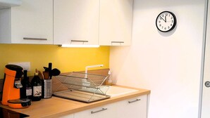 A kitchen with white cabinets, a sink, a clock, and a coffee maker. - Beachfront Villa with WiFi, Terrace & Parking - Sleeps 4 (Capbreton)