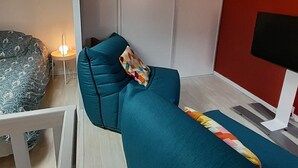 A modern living room with a teal sofa, a patterned armchair, and a small side table with a lamp. - Beachfront Villa with WiFi, Terrace & Parking - Sleeps 4 (Capbreton)