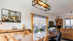 Une cuisine moderne avec une table à manger en bois, des chaises et un four encastré.