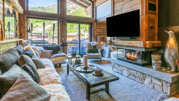 A cozy log cabin interior with a fireplace, a large flat-screen TV, and a sofa set. - Luxury Duplex in Val-d'Isère with Jacuzzi and Hammam (Val-d'Isère)