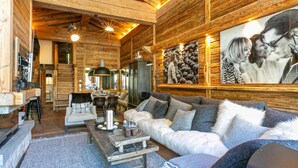 A cozy log cabin interior with a fireplace, wooden walls, a sofa set, and a dining area. - Luxury Duplex in Val-d'Isère with Jacuzzi and Hammam (Val-d'Isère)