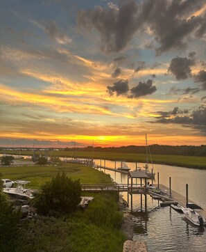 A marina with boats docked, a pier extending into the water, and a sunset in the background. - Oak Grove Cottage at Fernandina Beach (Fernandina Beach)
