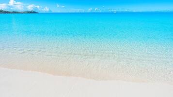 Escape to a serene beach paradise with crystal-clear waters and a pristine white shore.