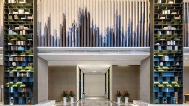 A modern lobby with a central walkway flanked by tall bookshelves. - Huanlesong Hotel (Jiaxing Zhongguancun Wanli Square) (Jiaxing)