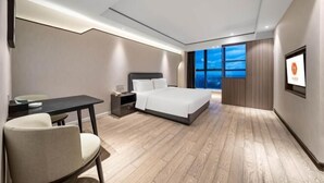 A modern hotel room with a bed, a desk, and a chair. - Huanlesong Hotel (Jiaxing Zhongguancun Wanli Square) (Jiaxing)