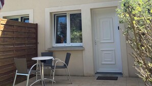 A building named "Le Sherman" with a tiled roof, a wooden fence, a window, and a door. - Résidence de Tourisme Le Sherman (Colleville-sur-Mer)