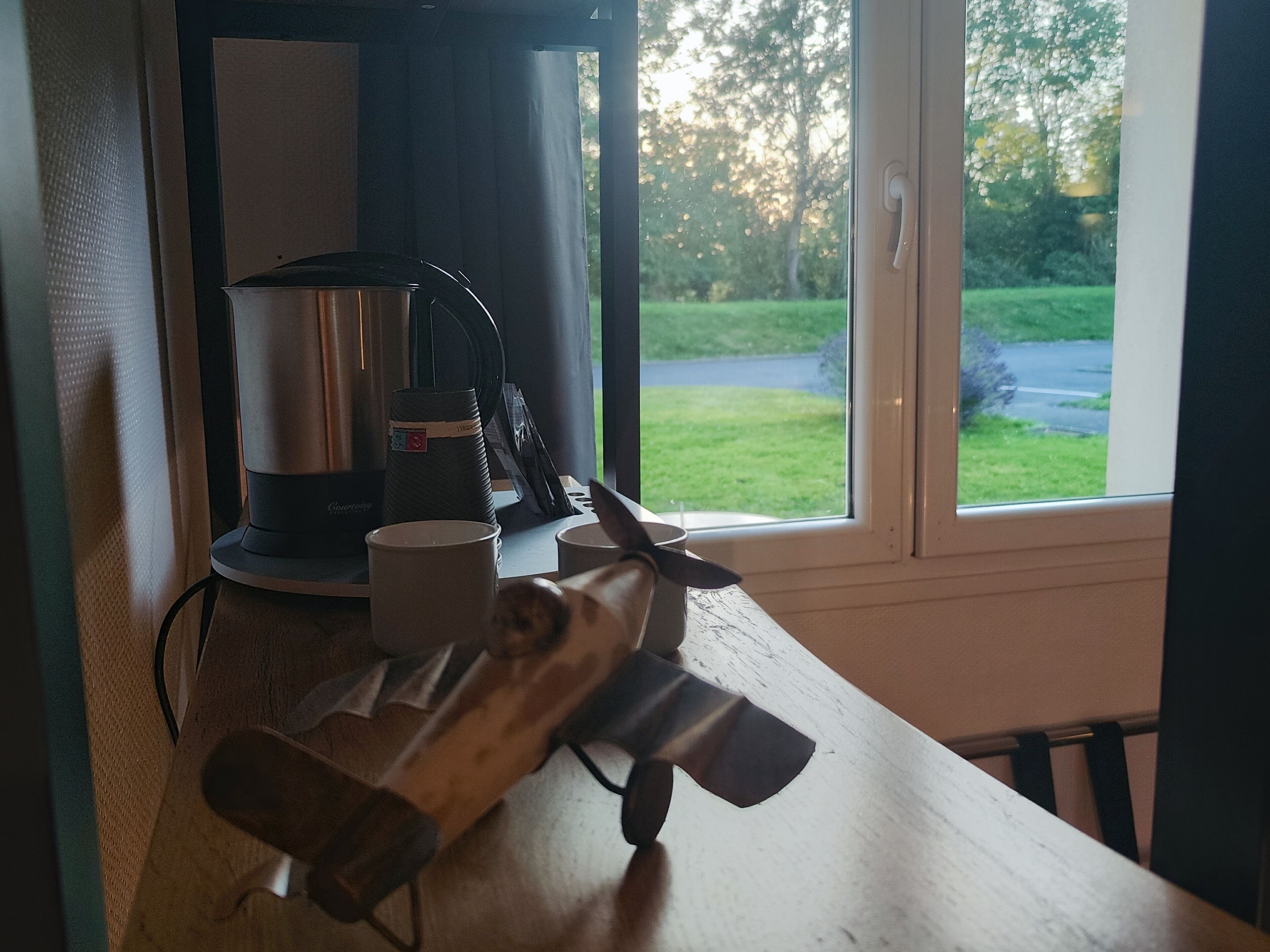 Un comptoir de cuisine avec une machine à café, une tasse et un couteau.