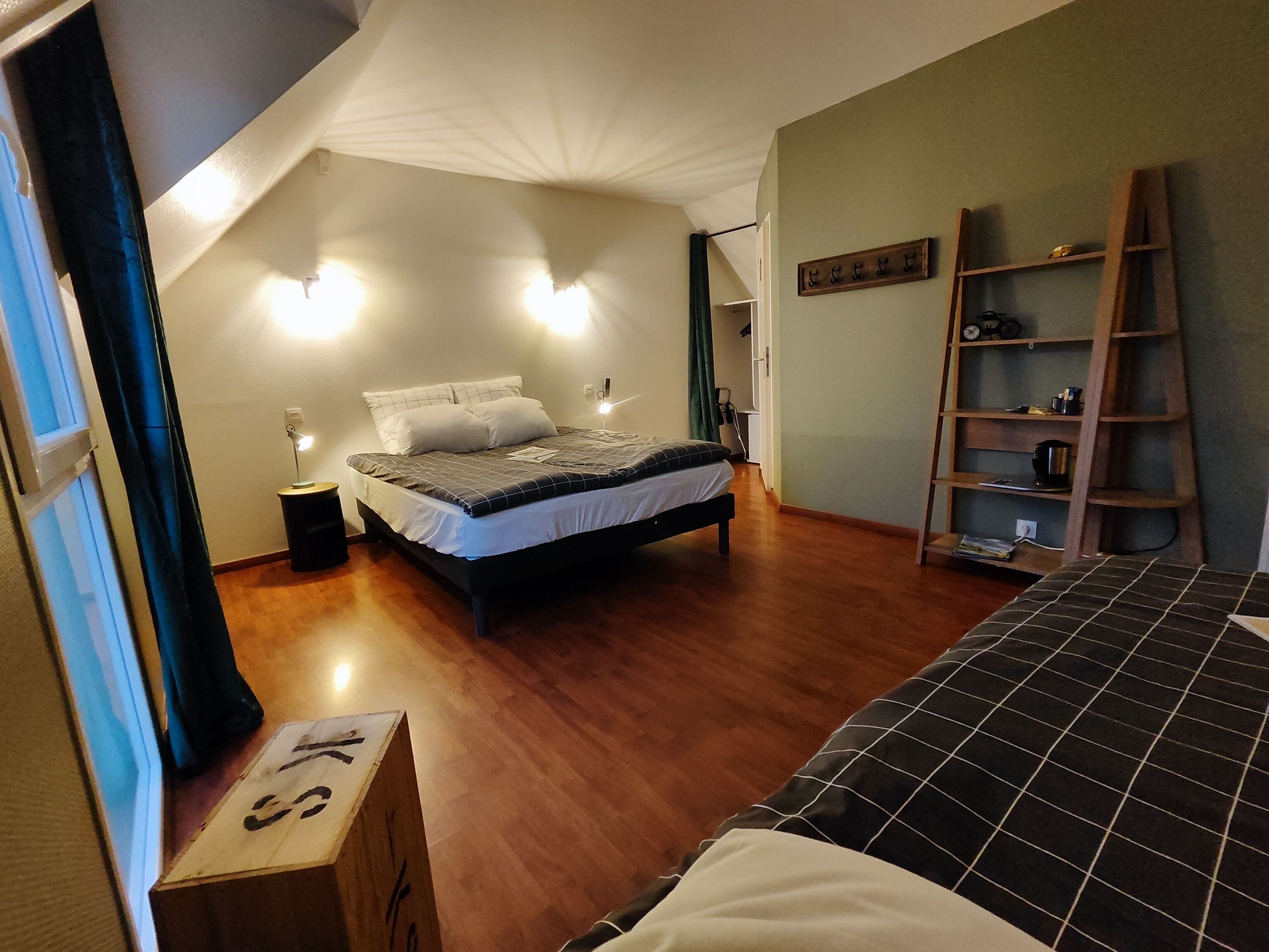 Un dormitorio con cama, mesita de noche y escalera de madera.