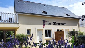 A building with a sign reading "Le Sherman." - Résidence de Tourisme Le Sherman (Colleville-sur-Mer)