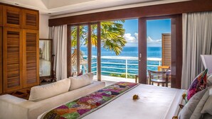 Una habitació d'hotel amb un llit gran, un sofà i vista a l'oceà.