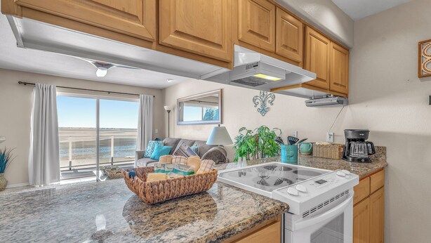 A kitchen with wooden cabinets, a built-in oven, and a granite countertop. - Top Floor, Ocean View Condo in The Heart of The Taft District in Lincoln City (Lincoln City)