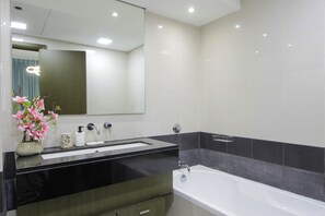 A modern bathroom with a black countertop, white sink, and a large mirror.