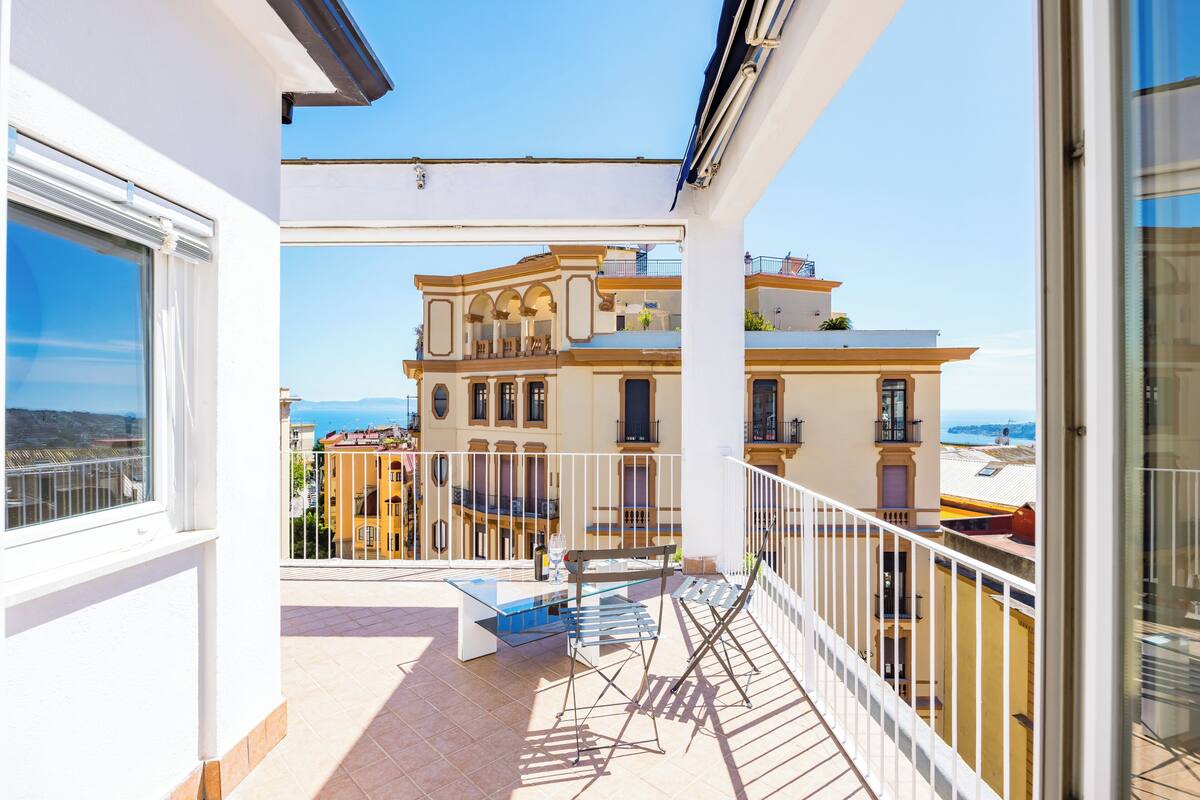 A balcony with a view of a building with balconies and a clear sky.