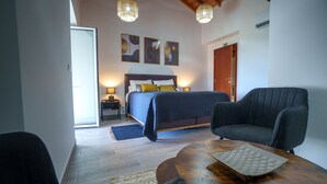 A bedroom with a bed, bedside tables, a chair, and a table. - AMARELO the YELLOW room (Feteira)