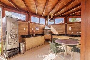 Cocina compacta con refrigerador, estufa y comedor.