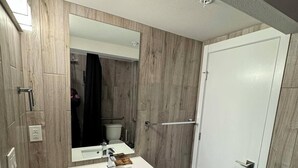 A modern bathroom with a white sink, mirror, and wooden walls. - Cozy studio in enchanting Seattle with AC, WiFi (Seattle)