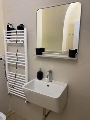 Chuveiro, secador de cabelo, bidê, toalhas de banho